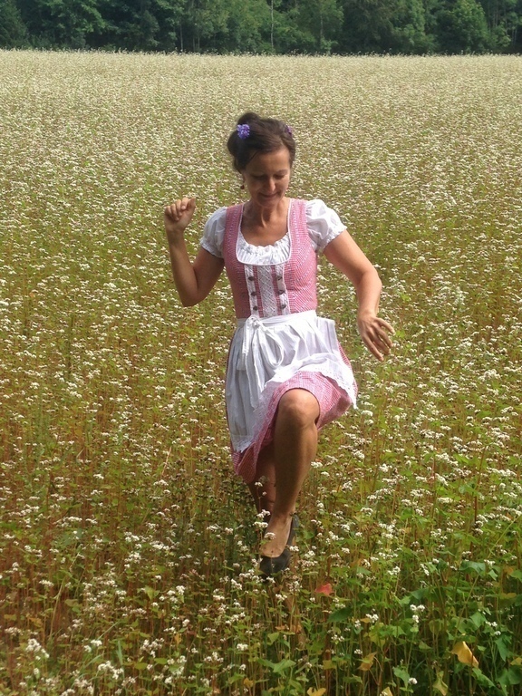 Right behind the house walking through a wild flower meadow and dressed in a "Dirndl" 