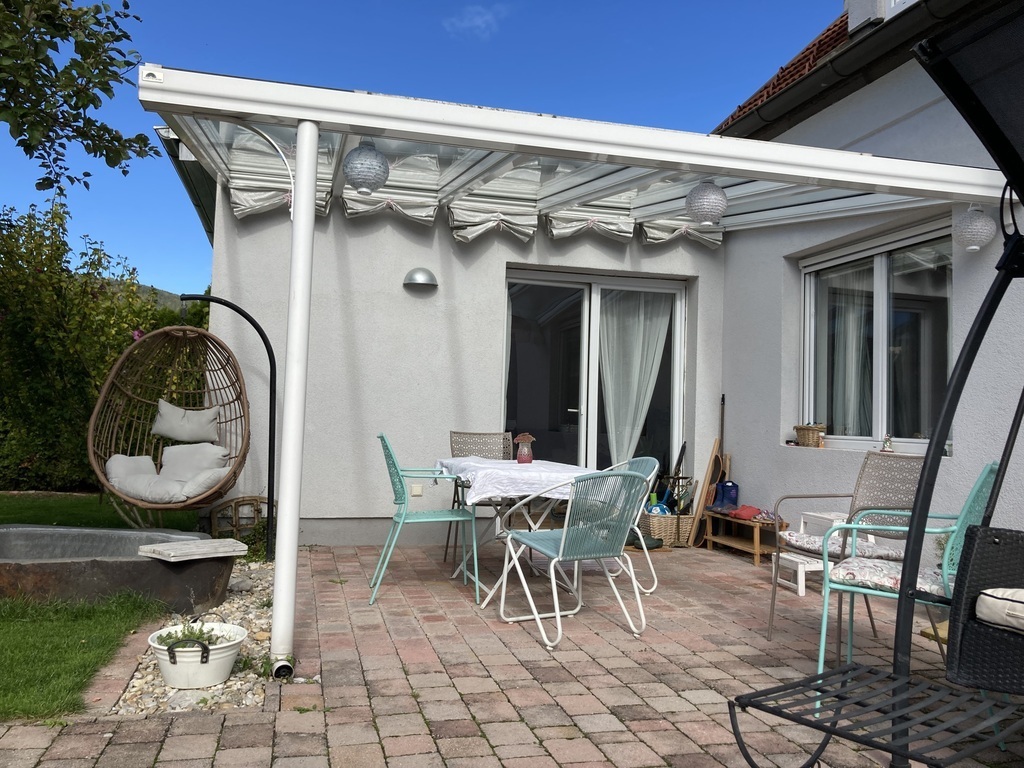 Überdachte Terrasse mit Tisch, Stühle, Hängesessel, Hollywoodschaukel, Sonnenschirm 