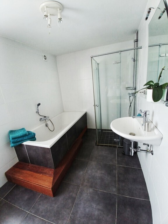 Salle de bain avec baignoire xxl, douche à l'italienne et lavabo. 