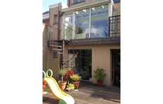 The room on the ground floor is the play room, above it the main kitchen flooded with light because of the glass house.