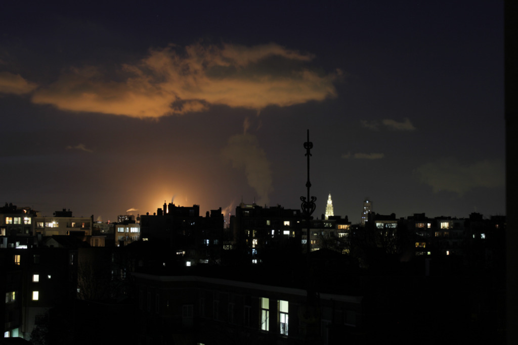 View from the living room at night, with the Antwerp Cathedral lighting up next to the harbor.