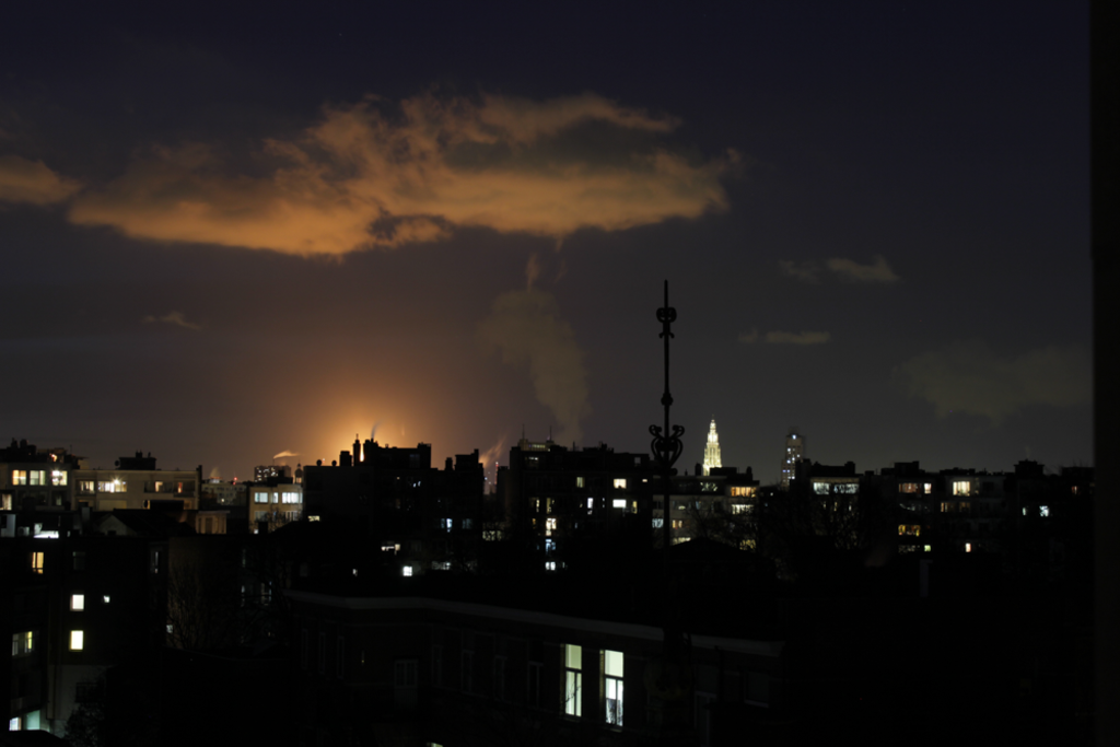 View from the living room at night, with the Antwerp Cathedral lighting up next to the harbor.