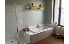 Large bathroom with bath, shower, toilet and two sinks on the first floor.