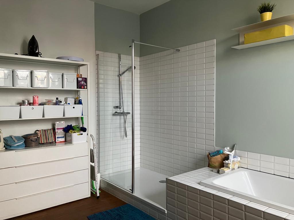 Large bathroom with bath, shower, toilet and two sinks on the first floor.