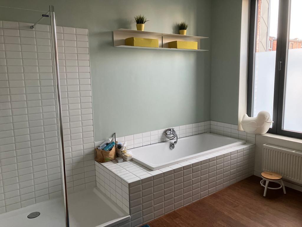 Large bathroom with bath, shower, toilet and two sinks on the first floor.