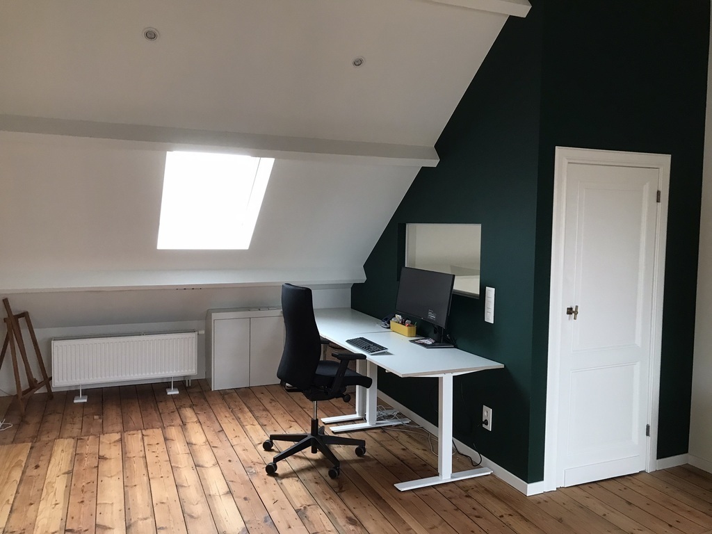 Spacious, bright attic with desk and sofa on the third floor.