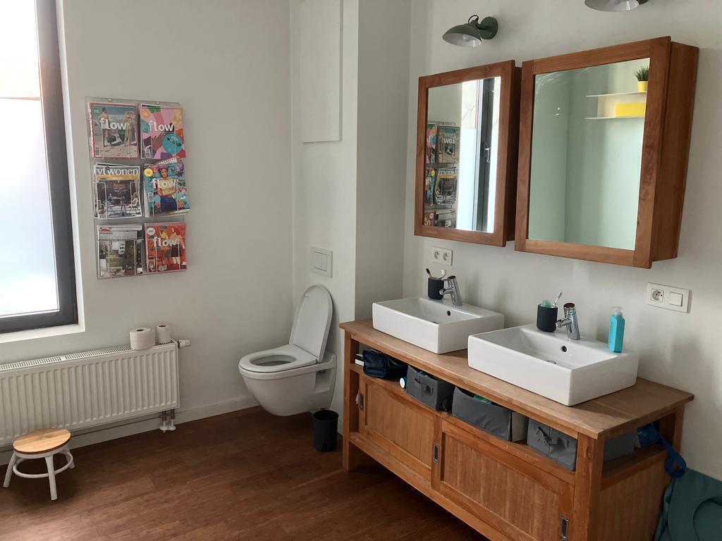 Large bathroom with bath, shower, toilet and two sinks on the first floor.
