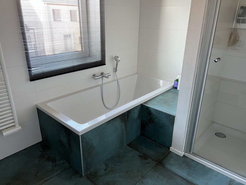 Bathroom with bathtub, rain shower and double sink