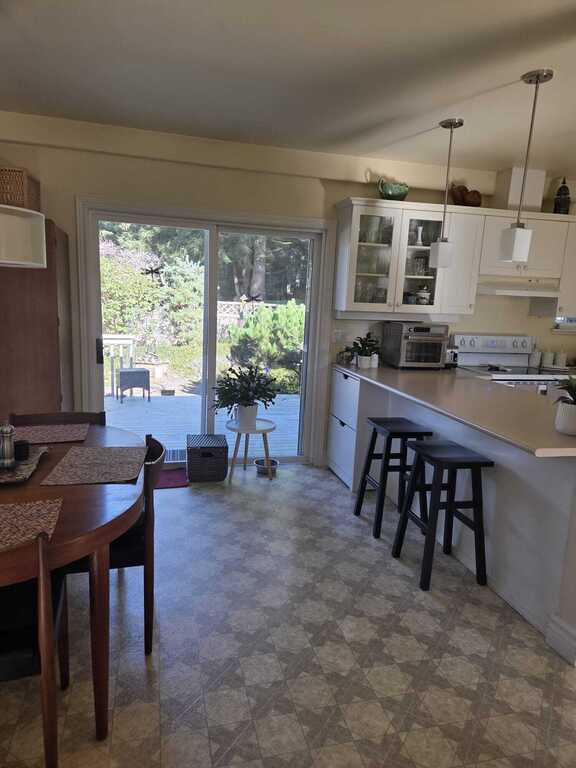 Sliding glass door leads to the enclosed garden and summer house.