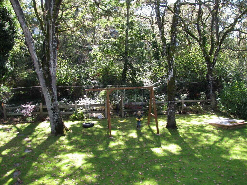 View from deck of yard with swing set & sandbox 