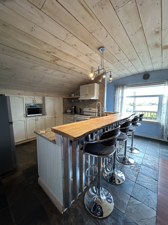The kitchen with a breakfast bar and seating for 4 people.