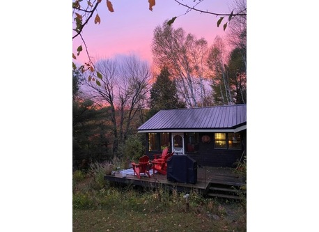 The front porch overlooks the pond. There are four Muskoka chairs perfect for morning coffee or night-time star gazing.