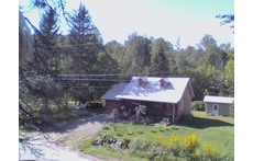 Vue d'ensemble d'une petite maison canadienne et de terrain, paisible et enchanteur.