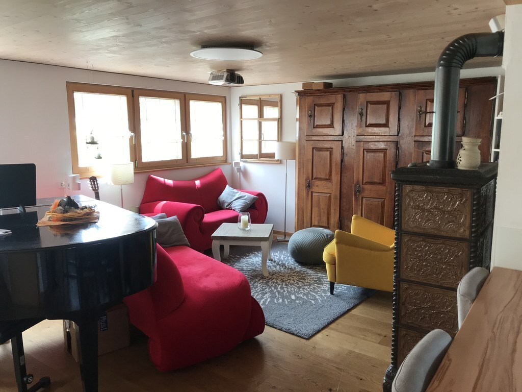 Living room with grand piano and wood stove