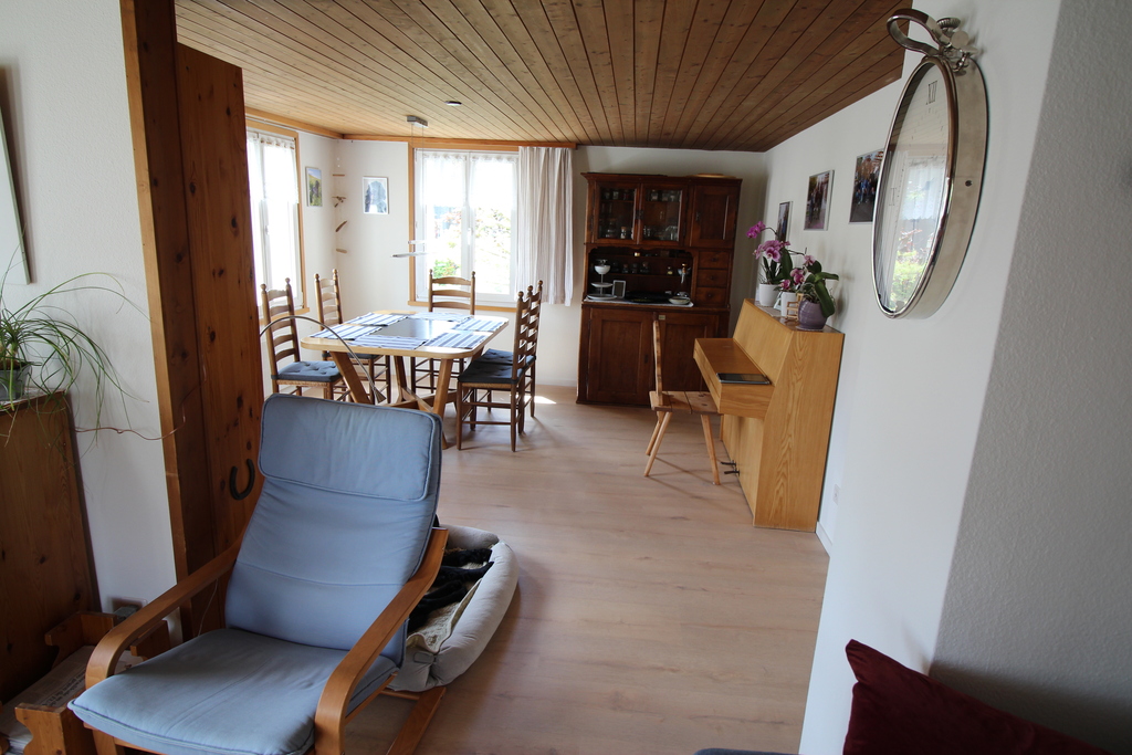 Esszimmer mit grossem Esstisch und Klavier.