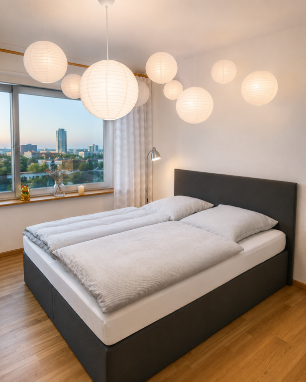 Helles, ruhiges Schlafzimmer mit komfortablem Doppelbett und grossen Fenstern – ideal für erholsame Nächte