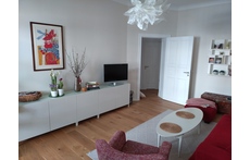 Wohnzimmer mit Zugang zum überdachten Balkon