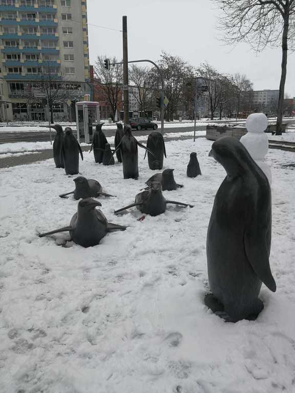 The bronze sculptures of penguins look as if they are in their natural environment in the snow.