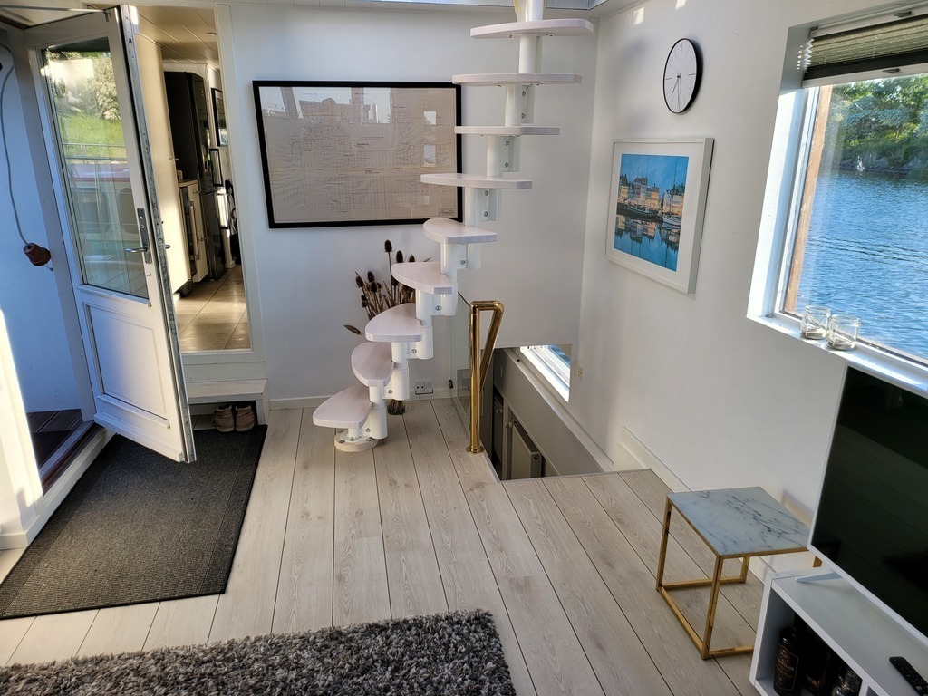 The houseboat: The living room with stairs to the upper deck and access to the kitchen and the descent to the bedroom. 