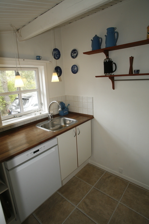 Køkken med elkeddel kaffemaskine og nespresso maskine og microovn.