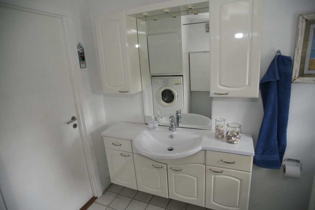 Badeværelse med brusebad, puslebord og babybadekar.