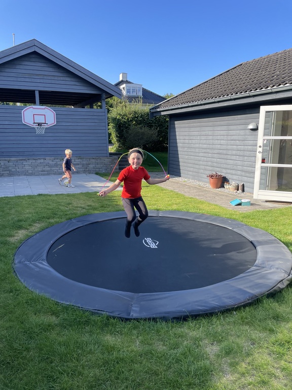 Trampoline and basketball hoop in the front yard