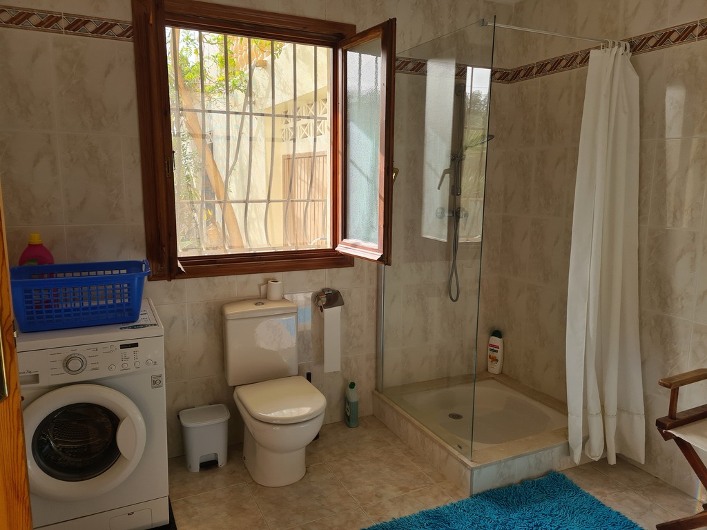 badkamer met wasmachine en douche