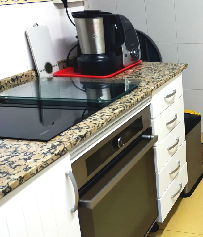 Cocina: encimera de inducción, horno y robot de cocina.