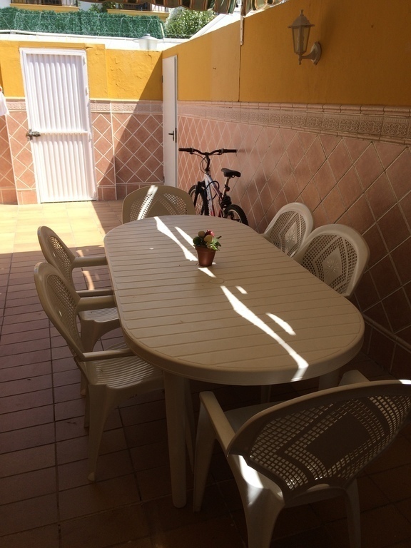 Patio trasero con trastero, tendedero y acceso a aparcamiento en superficie.