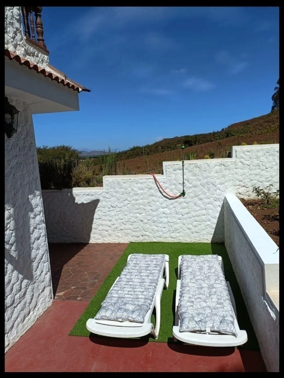 Zona de tumbonas y ducha en la terraza lateral de la vivienda