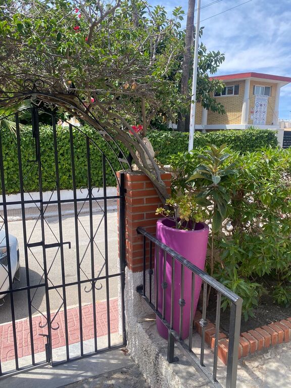 Puerta acceso al chalet desde dentro; recinto piscina y cafetería enfrente