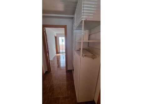 Photo of the living/dining room from the door to the kitchen. The window looks at the street. The door to the right is the entrance. 