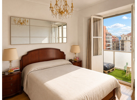 Bright master bedroom with balcony and city views