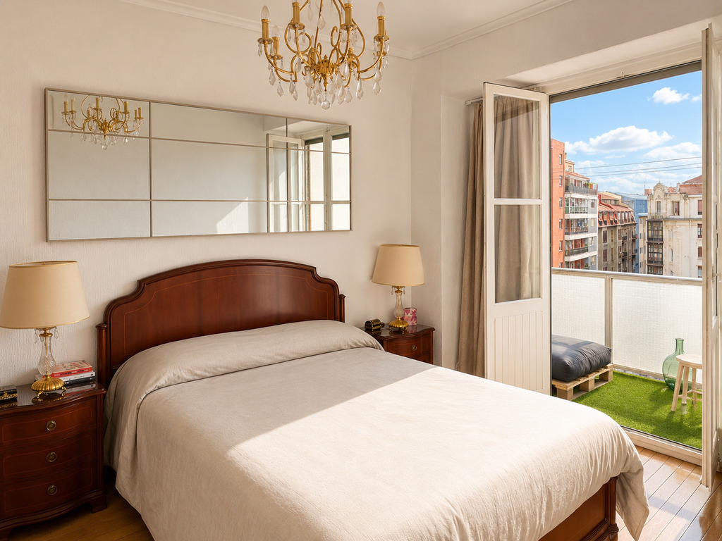 Bright master bedroom with balcony and city views