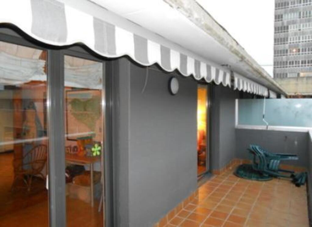 Terraza con mesa y toldo