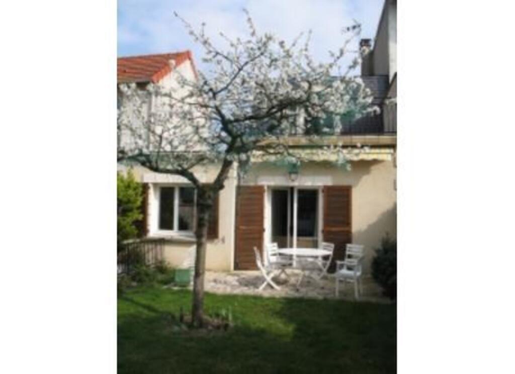 Back of the house with the bloomy cherry tree