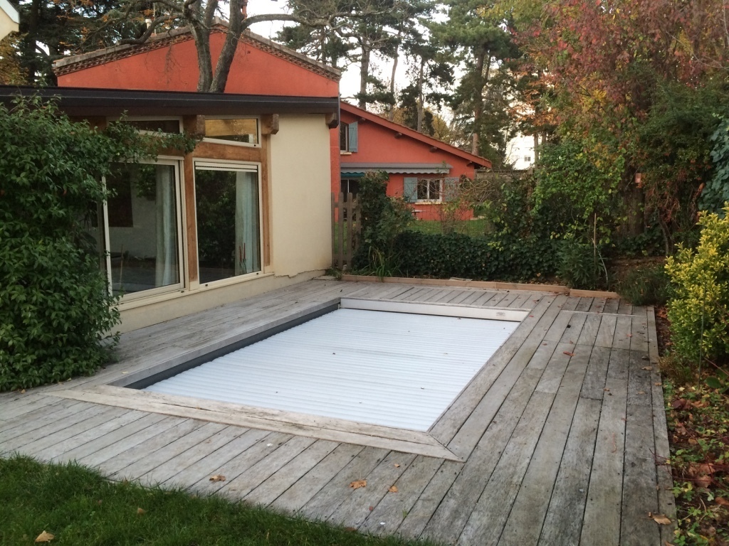 La piscine avec son volet de sécurité,  au fond la maison de nos voisins (des amis)