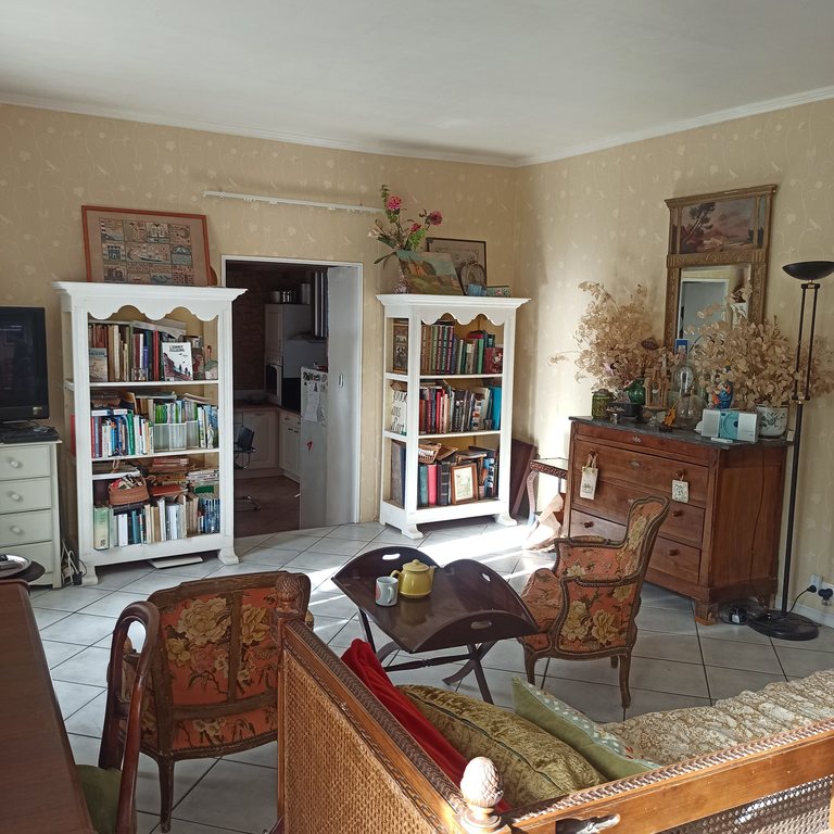 the sitting room with a piano , many books and magazines about south west 