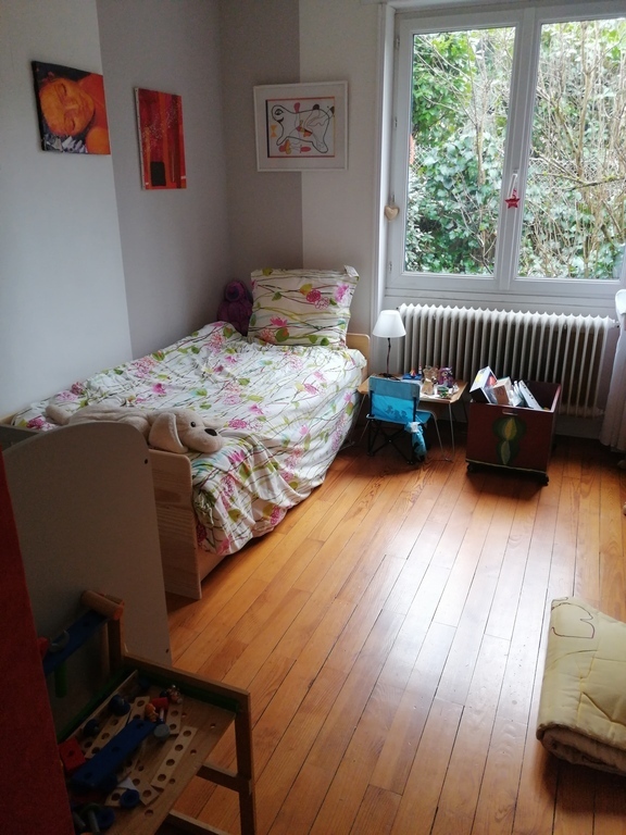 A bedroom with 2 beds and a baby bed