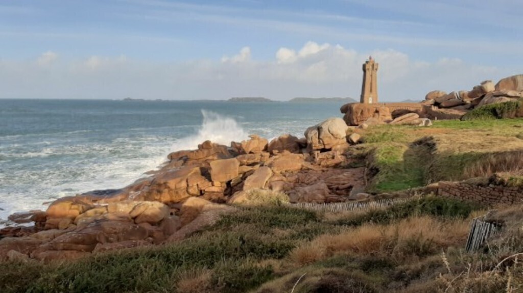 Red light house on pink granite coast