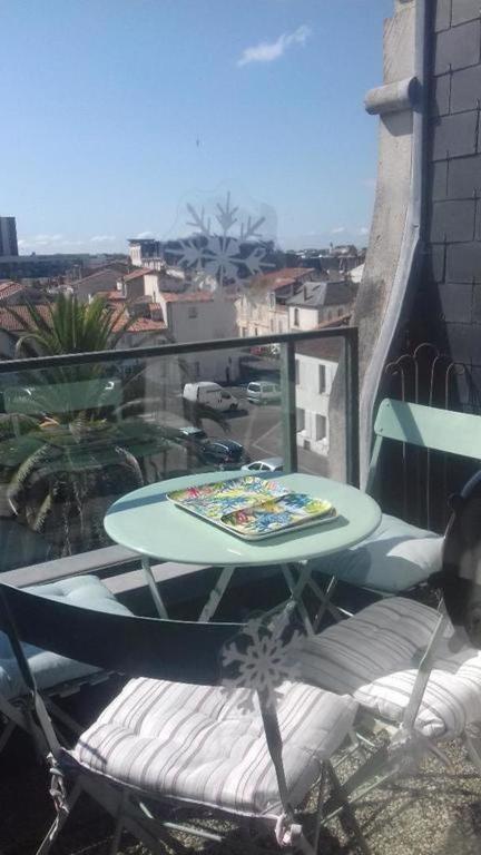 Balcon avec vue sur palmier et toits de La Rochelle