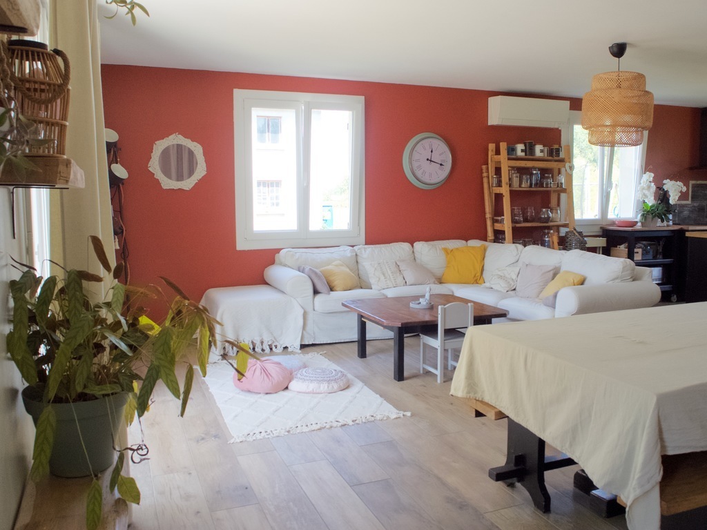 Grand canapé d'angle et coussins au sol.