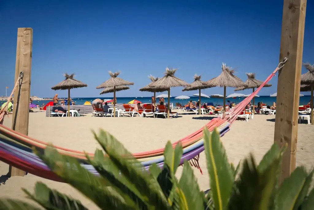 La plage en été avec ses clubs de plage : bars, restaurants, farniente...