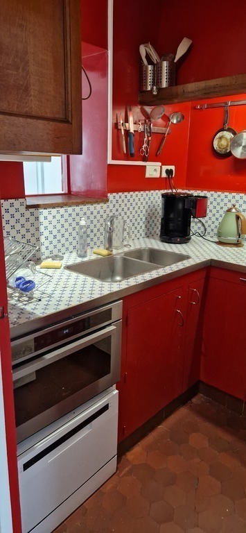 Kitchen with gas hubs, small fridge, oven and dishwasher
