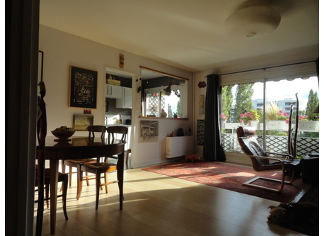 Living room facing west overlooking the wooded park, seen from the entrance. kitchen in the background.