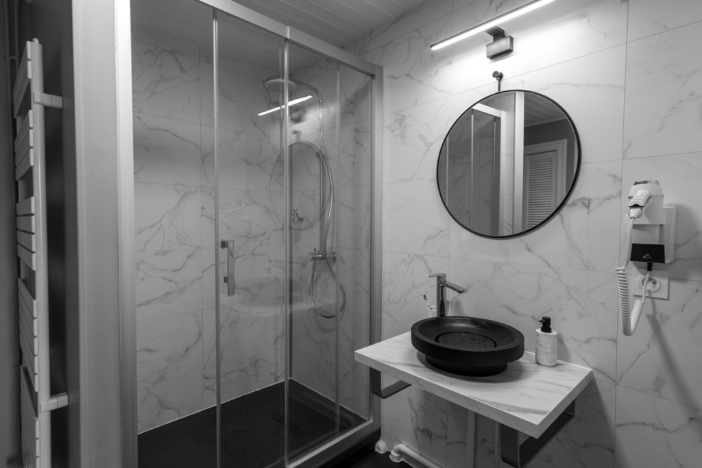 Salle d'eau numéro 1, lavabo, douche, meuble de rangement pour valise, habits