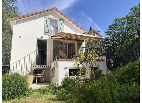 L'arrière de la maison vu du jardin : l'entrée, la terrasse, tout en bas un bureau avec un accès direct au jardin, tout en haut une chambre. 