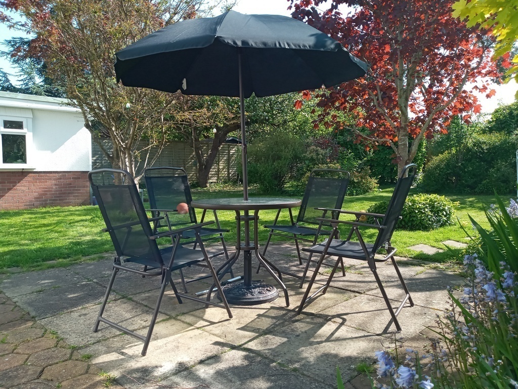 Garden with table for dining and lounger chairs in summer