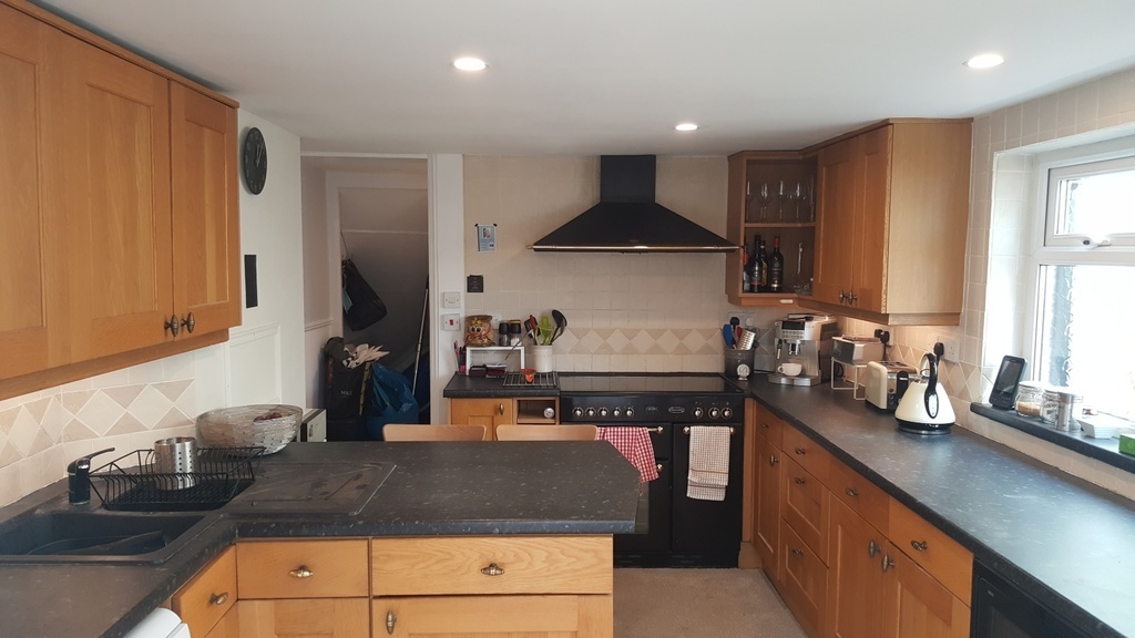 Kitchen. 2 ovens.  Stools.  TV. 