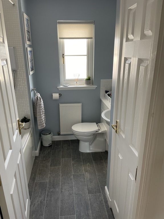Family bathroom with bath tub and over bath shower